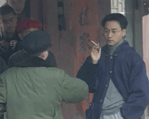 北京拍摄现场花絮图,画面中张国荣单手持烟揣摩剧情,不时比划剧中动作